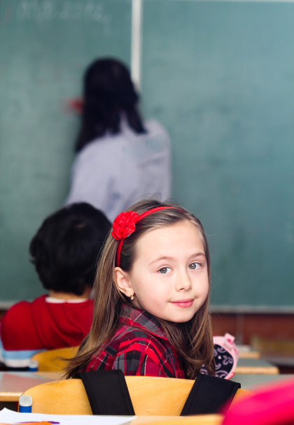 Szczęśliwa dziewczynka w szkole z jej przyjaciółmi arround - Zdjęcie, obraz