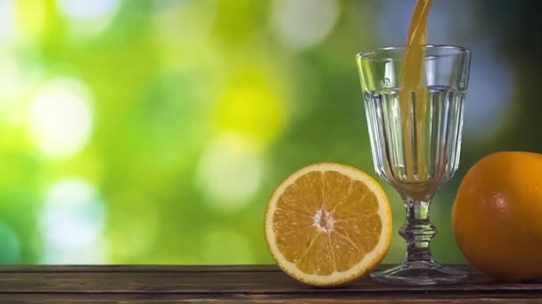 Супер медленное движение - апельсиновый сок наливается в стакан в солнечный день
 - Кадры, видео