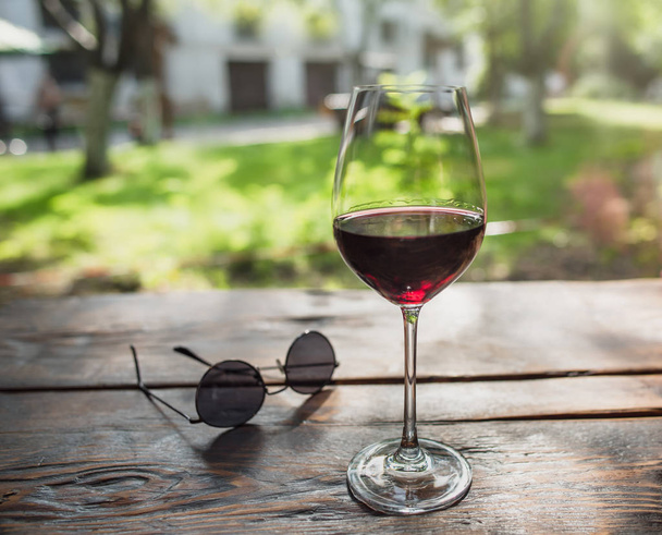 夏の庭の赤ワインのガラス - 写真・画像