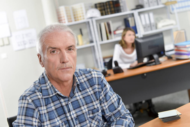 Senior man sat at his desk - Photo, image
