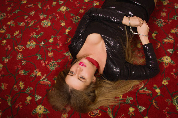 Kuristettu kaunis nainen mustassa mekossa makaa lattialla. Si
 - Valokuva, kuva