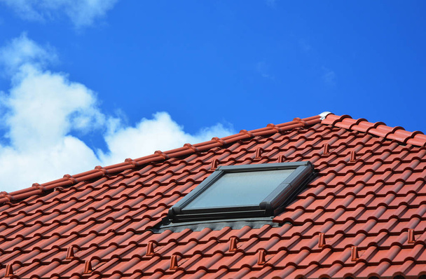 Dakraam op rode keramische tegels huis dak. Dakramen, dakvensters en zon Tunnels. - Foto, afbeelding