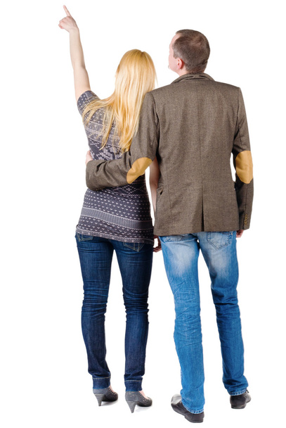 Back view of young couple pointing at wall. - Photo, Image