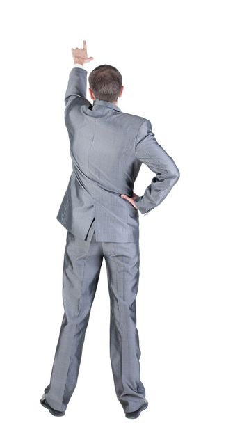 Back view of businessman pointing at wall - Valokuva, kuva