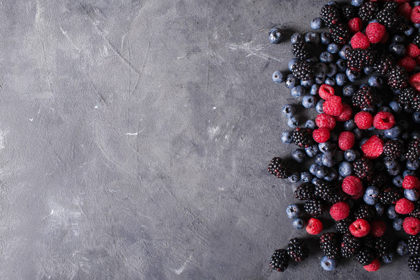 Raspberries, blackberries, blueberries a gray abstract background - Fotoğraf, Görsel