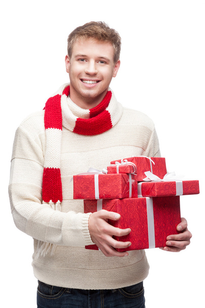 Young man holding many red christmas gifts - Valokuva, kuva