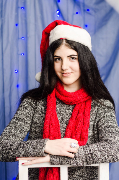 Sexy bella ragazza con lussuosi capelli biondi spessi in una gonna di tulle bianco che tiene una scatola regalo sullo sfondo degli interni e della neve di Capodanno azzurro
. - Foto, immagini