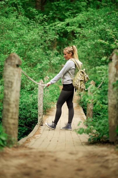 Mulher caminhante na ponte da floresta
 - Foto, Imagem