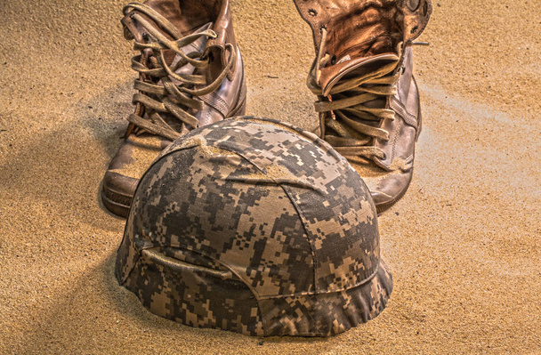 soldaat hoed laarzen en zand glas in de woestijn - Foto, afbeelding