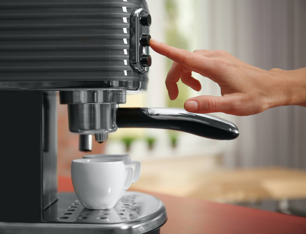 hand pushing button on coffee maker - Foto, afbeelding