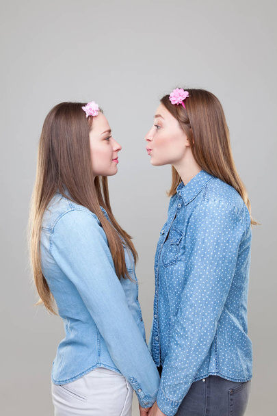 Estudio portait de hermanas gemelas jóvenes abrazando
 - Foto, imagen