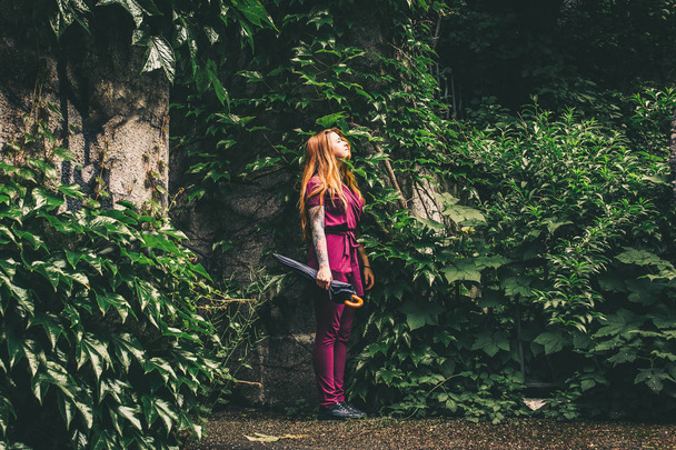 Γυναίκα να στέκεται στο πάρκο με ομπρέλα - Φωτογραφία, εικόνα