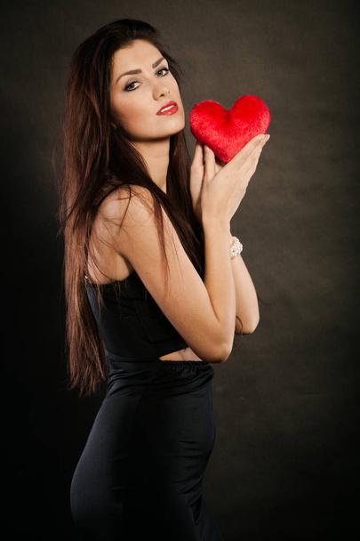 Beautiful woman holds red heart on black - Φωτογραφία, εικόνα