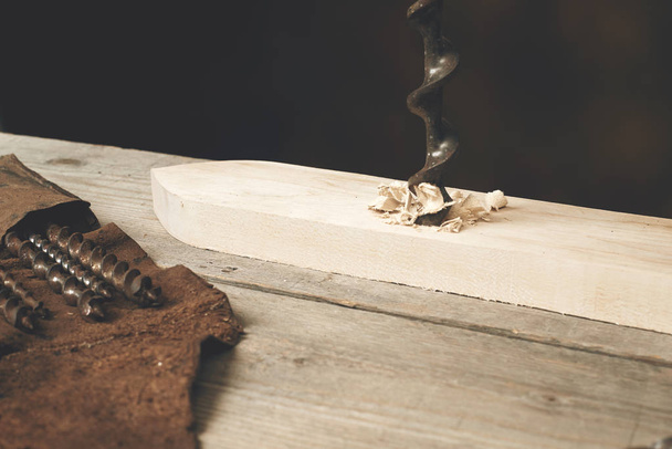 drilling wood with auger bit on a workbench - Fotoğraf, Görsel