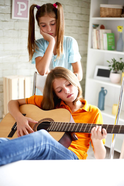 Gli adolescenti imparano a suonare la chitarra
 - Foto, immagini