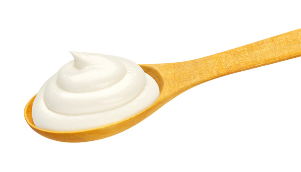 Crema agria en cuchara de madera aislada sobre fondo blanco - Foto, imagen