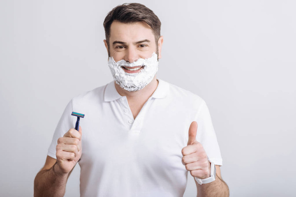 Portrait of handsome man posing with razor - Фото, зображення