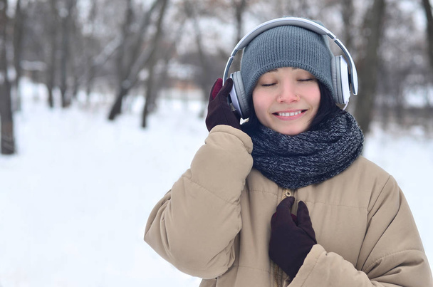 Зимний портрет молодой девушки в наушниках
 - Фото, изображение