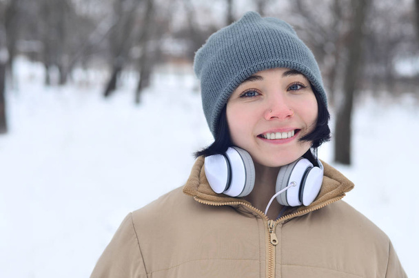 Χειμώνα πορτραίτο νεαρού κοριτσιού με ακουστικά - Φωτογραφία, εικόνα