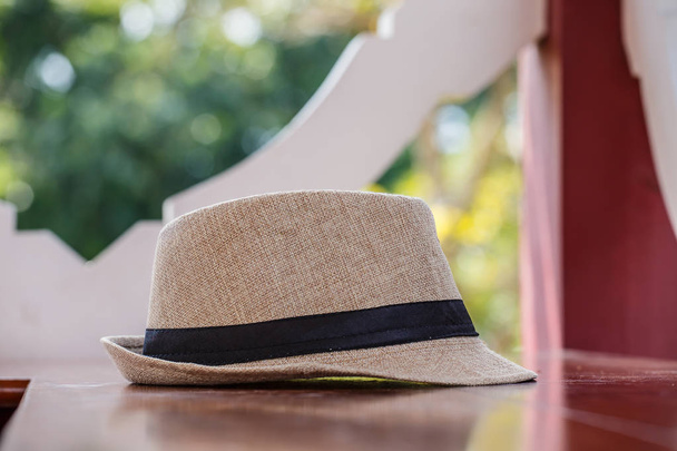 Pretty straw hat  on table background - Foto, afbeelding