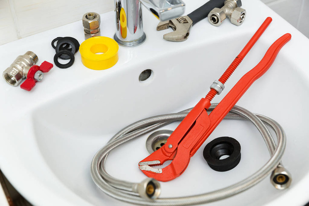 sanitair gereedschappen en werktuigen op wastafel in badkamer - Foto, afbeelding