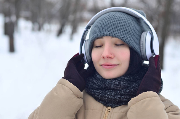 Winterporträt eines jungen Mädchens mit Kopfhörern - Foto, Bild