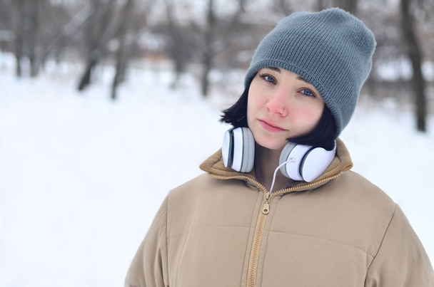 Winterporträt eines jungen Mädchens mit Kopfhörern - Foto, Bild