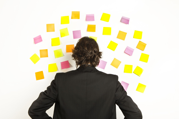 young businessman with postit reminder notes on the background - Foto, Imagen