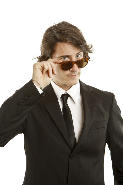 attractive young man wearing elegant black suit and sunglasses - Foto, afbeelding
