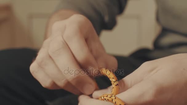 Mans kezében egy hegymászó csomót árukapcsolás egy kötélen - Felvétel, videó