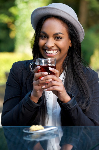 Ritratto di una bella ragazza afroamericana sorridente che beve tè
 - Foto, immagini