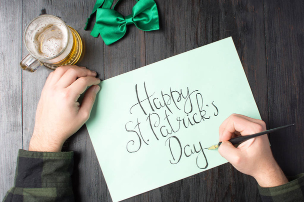 Homme écrivant une carte de jour Happy St Patrick
 - Photo, image