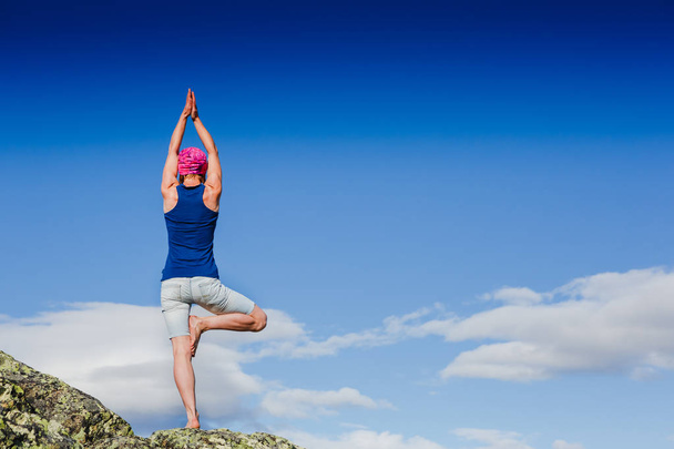 Young woman is practicing yoga in the mountains - Valokuva, kuva