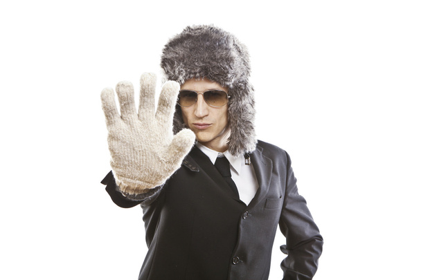 atraktivní mladý muž nosí elegantní černé šaty, sluneční brýle a ruské klobouk - Fotografie, Obrázek