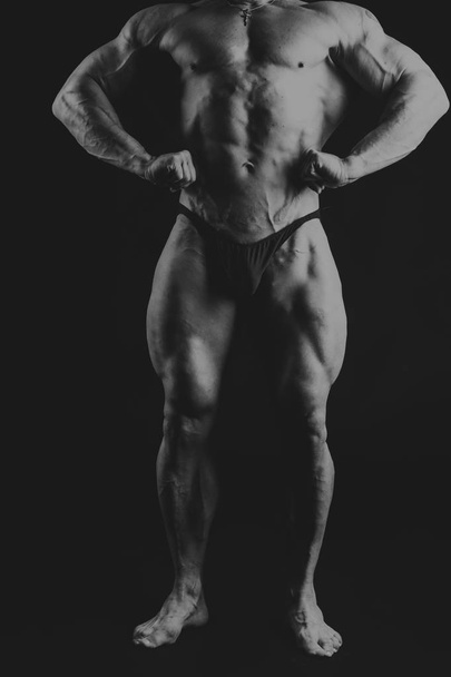 Un homme avec un corps musclé magnifique sur un fond noir
 - Photo, image