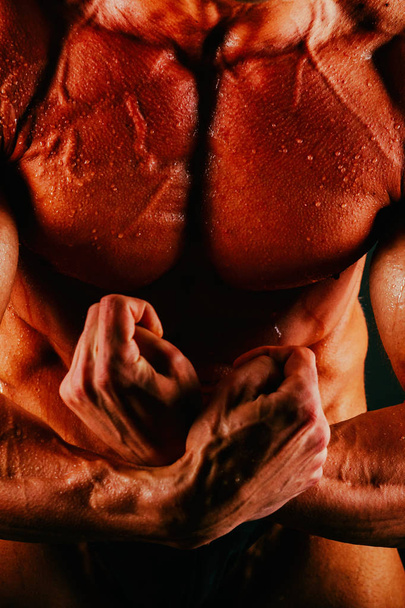 Healthy muscular body bodybuilder on a black background - Foto, immagini