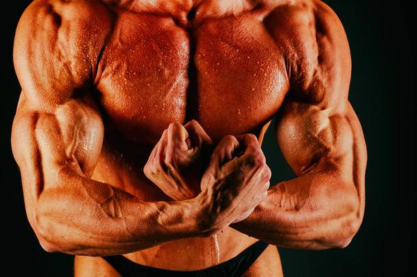 bodybuilder muscolare sano su uno sfondo nero
 - Foto, immagini
