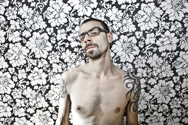 skinny tattoo guy on floral background - Foto, imagen