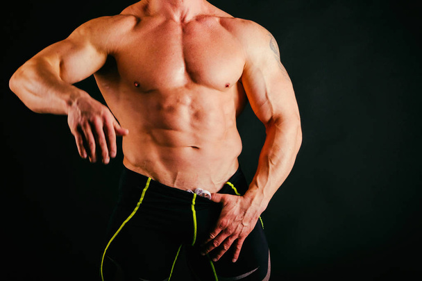 Trained muscular man on a black background - Fotó, kép