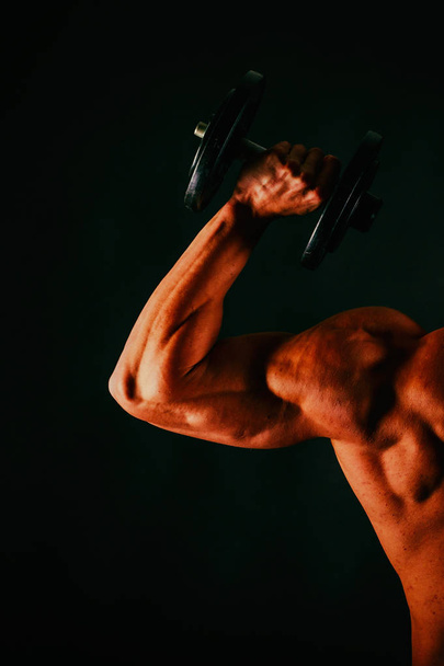 Men's muscles on a black background - Foto, Imagen
