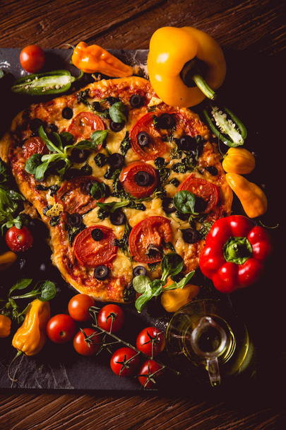 Fresh and tasty homemade pizza on wooden table with ingredients - Foto, Imagem
