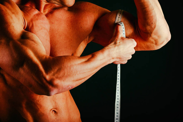 Músculos masculinos em um fundo preto
 - Foto, Imagem