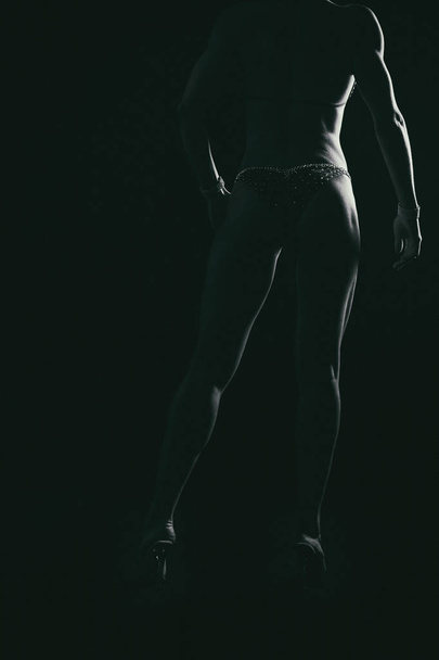 hermosa figura deportiva sobre un fondo negro
 - Foto, Imagen