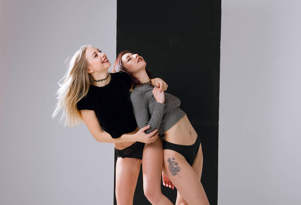 Two beautiful girlfriends in lingerie standing on a white background - Fotografie, Obrázek