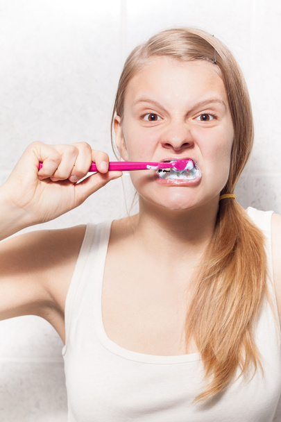 Chica joven está limpiando sus dientes
 - Foto, imagen