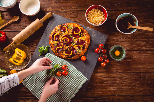 Fresh and tasty homemade pizza on wooden table with ingredients - Photo, Image