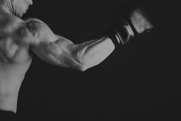 Powerful bodybuilder on a black background - Foto, Imagem