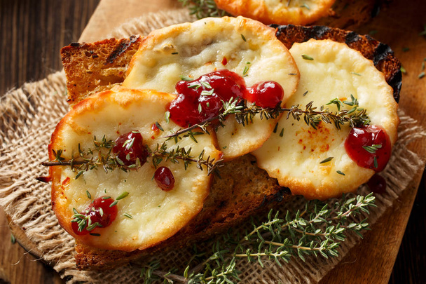 Tostadas con queso ahumado y mermelada de arándanos rojos silvestres
 - Foto, imagen