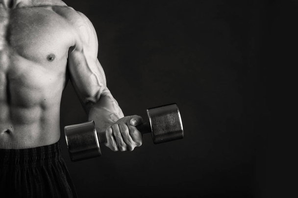 muskulöser männlicher Körper auf schwarzem Hintergrund - Foto, Bild