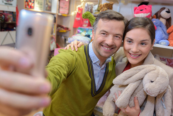 parents-to-be shopping choosing plush for their kid - Photo, Image